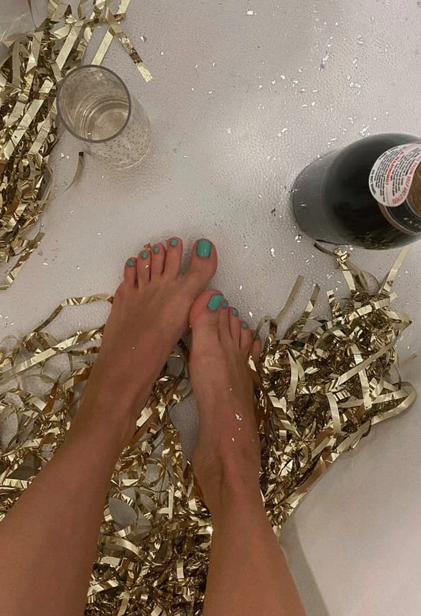 Bare feet softly posed with ankles crossed, indoor cozy setting, premium aesthetic feet photo